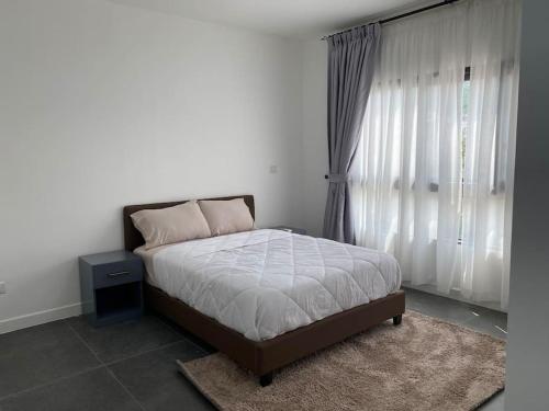 een slaapkamer met een bed en een raam met gordijnen bij Modern 2 bedroom Townhouse in Accra in Aiyimensa