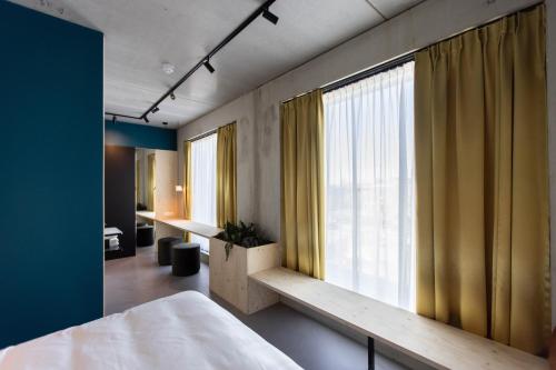 a bedroom with a bed and a large window at the urban hotel Moloko - rooms only - unmanned - digital key by email in Enschede