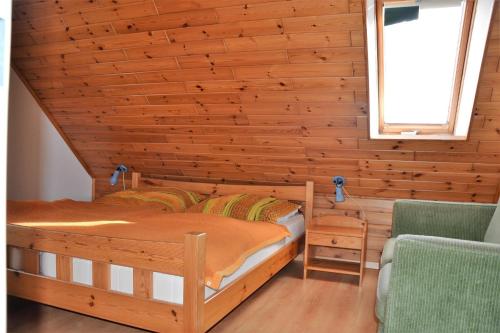 een slaapkamer met 2 bedden en een houten muur bij *Schmitz - Ferienwohnungen in Greetsiel
