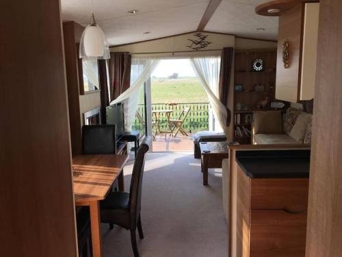 a kitchen and living room with a view of a porch at Dymchurch Caravan Park on Romney Marsh in Dymchurch