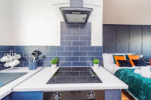 uma cozinha com fogão forno superior ao lado de uma cama em Luxury Studio Annexe, Heswall em Heswall