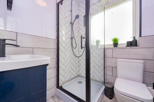 a bathroom with a shower with a toilet and a sink at Luxury Studio Annexe, Heswall in Heswall