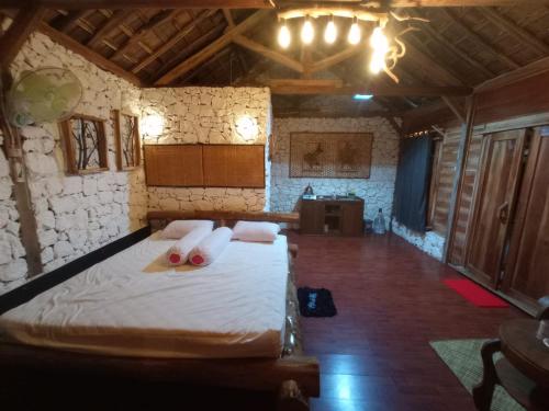 Schlafzimmer mit einem Bett mit weißer Bettwäsche und Kissen in der Unterkunft Nirankara Nglolang Resort in Baron