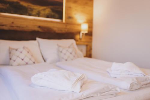 two beds with white sheets and pillows on them at Chalet Molly by we rent in Zell am See