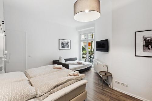 a white living room with a bed and a couch at Hotel 1A Apartment Berlin in Berlin