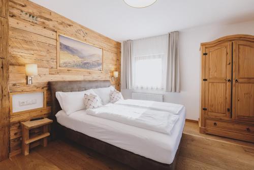 um quarto com uma cama grande e uma parede de madeira em Chalet Molly by we rent em Zell am See