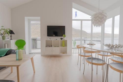 a white living room with a table and chairs at Waterfront retreat - 2 BR Boathouse 