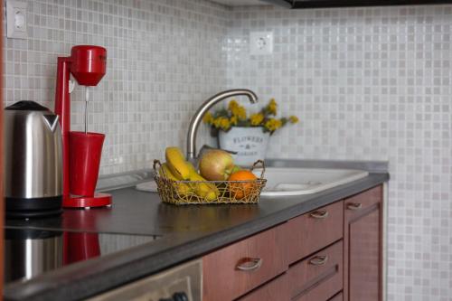 a kitchen counter with a basket of fruit on a sink at Cosy Fourka Beachfront apartment in Skála Foúrkas