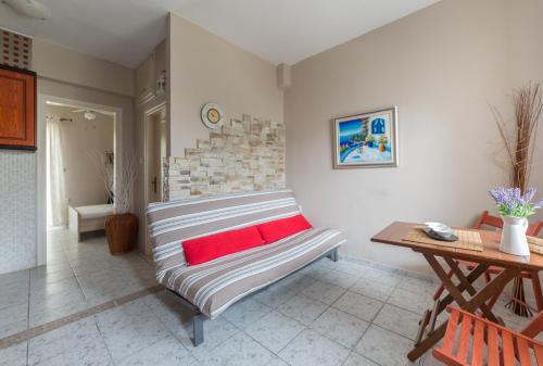 a living room with a couch with a red pillow at Cosy Fourka Beachfront apartment in Skála Foúrkas