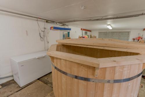 a large wooden barrel in a room with a refrigerator at Waterfront retreat - 2 BR Boathouse in Oyrareingir