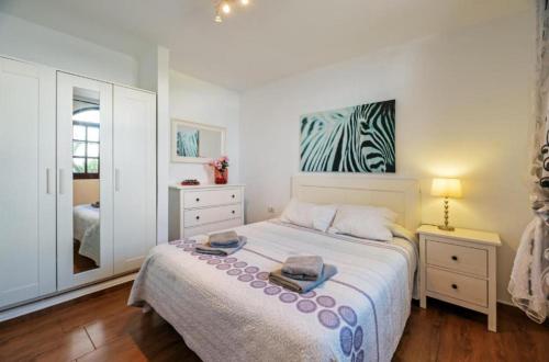 een slaapkamer met een bed met twee handdoeken erop bij Gibshouse Megan in Puerto del Carmen
