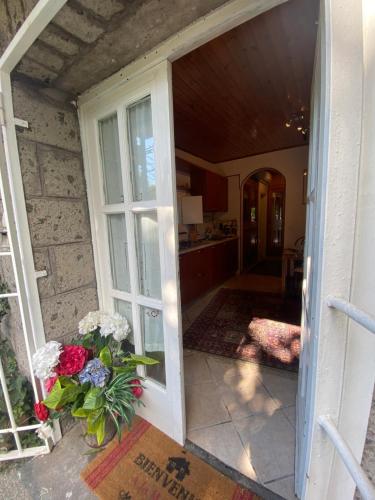 een open deur naar een keuken met een vaas met bloemen bij La maison des citrons in Meta