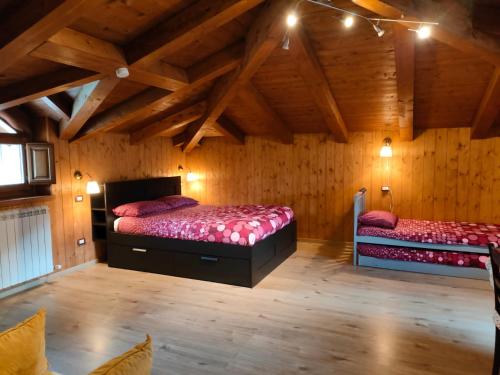 two beds in a room with wooden walls at B&B Il Ghiro-Country House in Mormanno
