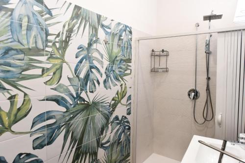 baño con ducha y un mural de plantas en Ristorante Paisà. Cibo e Ospitalità en Agnone