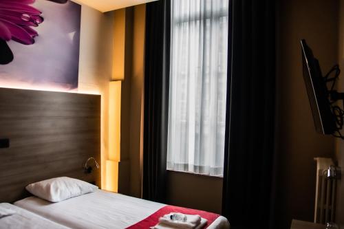 a hotel room with a bed and a window at Hotel Industrie in Leuven