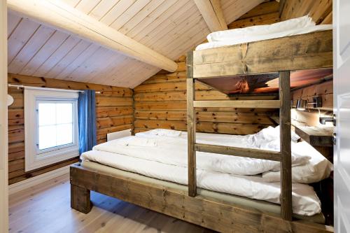 a bedroom with two bunk beds in a log cabin at Lake View Apartment 4 bedrooms and 2 bathrooms in Sykkylven