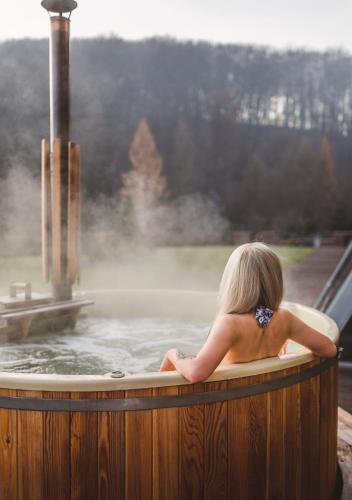 a woman sitting in a hot tub with a fountain at Młyn Jacka Hotel & Spa in Wadowice