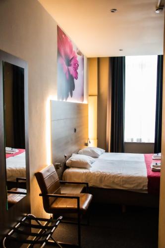 a hotel room with a bed and a chair at Hotel Industrie in Leuven