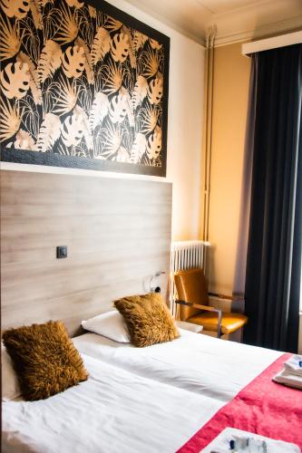a hotel room with a white bed with a wall at Hotel Industrie in Leuven