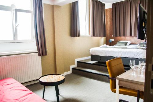 a hotel room with a bed and a table at Hotel Industrie in Leuven