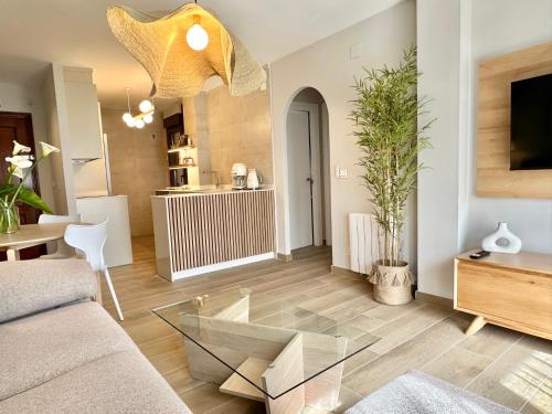 a living room with a couch and a glass table at Apartamentos Noja Playa in Noja