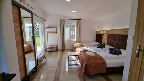 Lubiana Resort في Lubiana: غرفة فندقية بسريرين واريكة