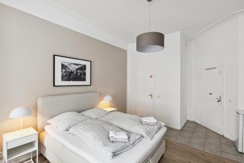 een witte slaapkamer met een bed in een kamer bij Hotel 1A Apartment Berlin in Berlijn