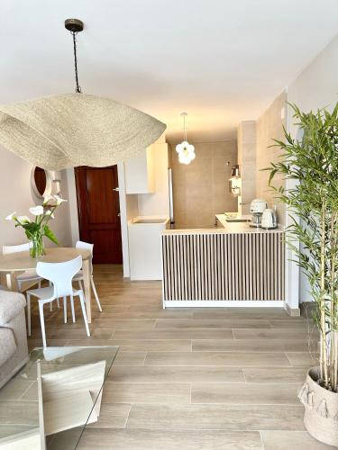 a living room with a table and a kitchen at Apartamentos Noja Playa in Noja