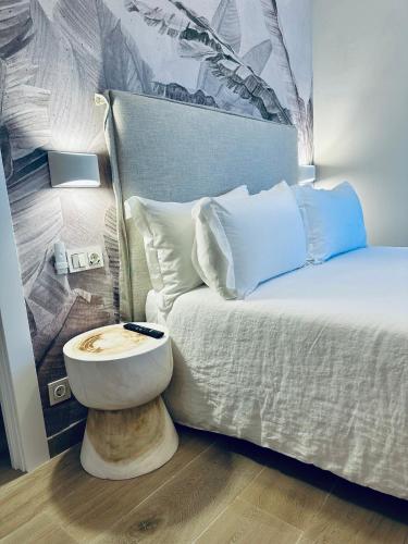 a bedroom with a bed with a table next to it at Apartamentos Noja Playa in Noja