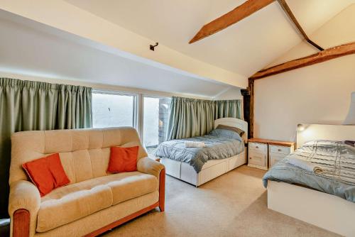 a living room with a couch and a bed at 2 Bed Barn conversion in Tibenham