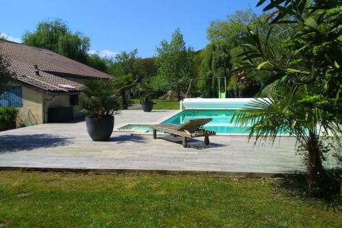 une terrasse avec un banc et une piscine dans l'établissement MAISON- Biaudos avec piscine chauffée, à Biaudos