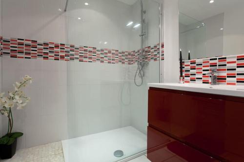 une salle de bain avec douche et lavabo dans l'établissement tiny house indépendante climatisée, à Moulès