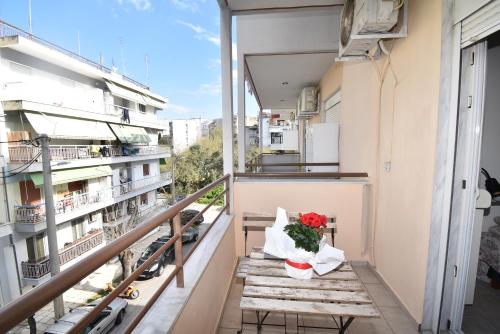 a bouquet of flowers sitting on a bench on a balcony at Central Apartment Thessaloniki-Easy Parking in Thessaloniki