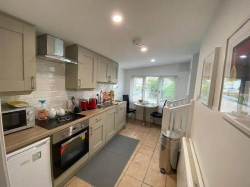 a kitchen with white cabinets and a stove top oven at Location, Location! Gorgeous 1 Bed Apt- Killarney in Killarney
