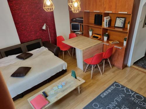 ブカレストにあるSunny Old Town Apartmentsのベッド2台、テーブル、椅子が備わる小さな客室です。