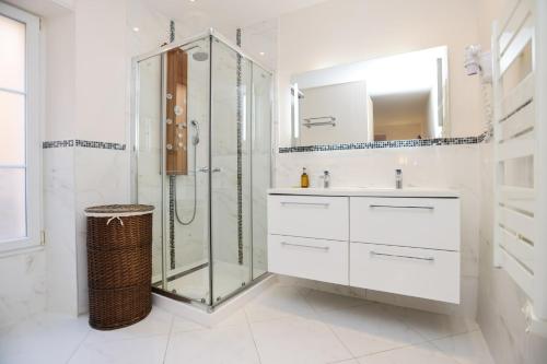 une salle de bain blanche avec une douche et un lavabo dans l'établissement IMMOGROOM - Beautiful and cosy- Suquet- near the beaches - AC, à Cannes