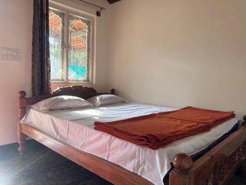 a bed in a bedroom with a stained glass window at Immanamane Homestay in Chikmagalūr