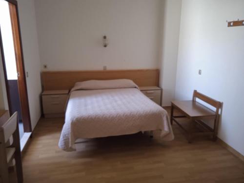 um quarto com uma cama, uma mesa e uma cadeira em Arcádia by Umbral em Fátima