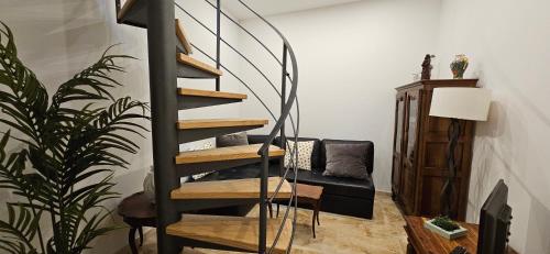 a spiral staircase in a living room with a couch at Bel & ancien appartement T3 rénové dans Sartène in Sartène