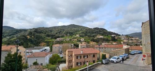 a town with cars parked in front of a mountain at Bel & ancien appartement T3 rénové dans Sartène in Sartène