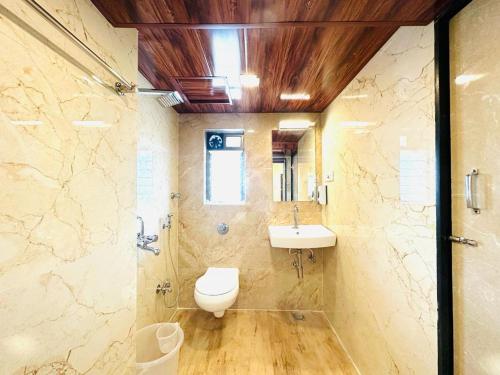 a bathroom with a toilet and a sink at Hotel Vashi Inn in Navi Mumbai