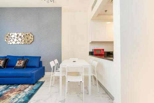a living room with a blue couch and a table at Lux BnB I Amna Tower I Panaromic Views in Dubai