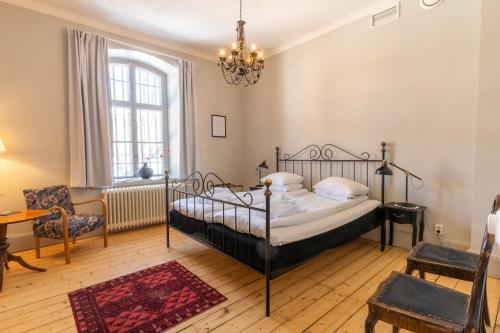 于默奧的住宿－格姆拉番格爾塞特酒店，一间卧室配有一张床、一把椅子和一个吊灯。