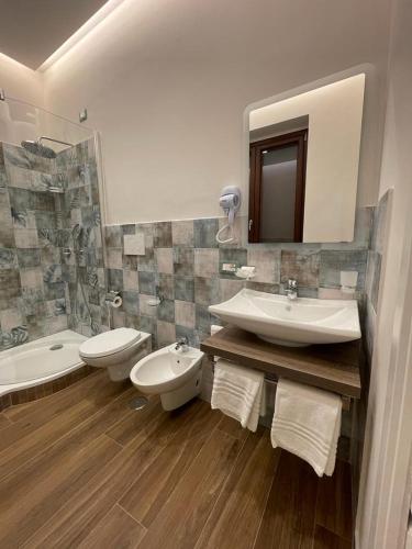 a bathroom with two sinks and a tub and a mirror at Villa Maera Ravello in Ravello