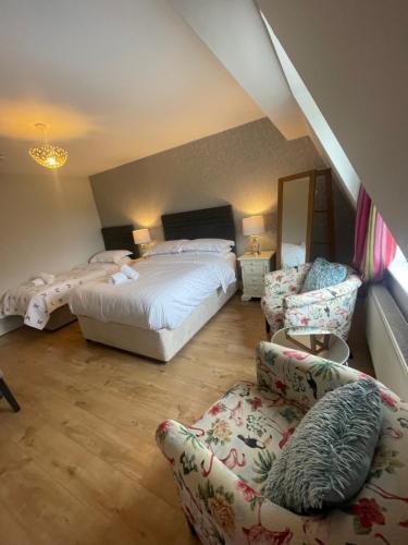 a bedroom with two beds and a couch and chairs at Beechwood House Accommodation in Blarney