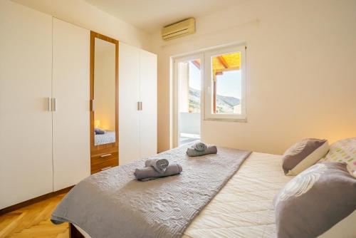 a bedroom with a bed with two slippers on it at Kob Orog good location with sea views and modern decor in Metajna