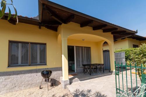 a yellow house with a patio and a table at GreenHouse del lago in Viverone