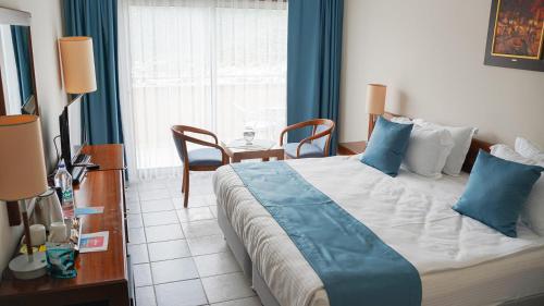 a bedroom with a large bed with blue pillows at Happy Hotel Kalkan in Kalkan