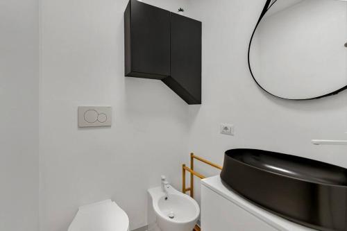 baño con lavabo negro y espejo en Alessia's Flat - San Luigi en Milán