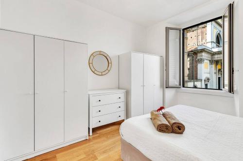 Habitación blanca con cama y ventana en Alessia's Flat - San Luigi en Milán